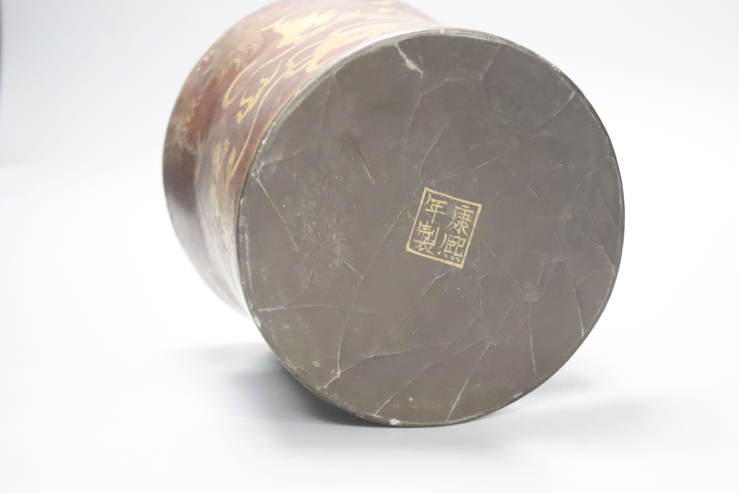 A Chinese lacquered brush pot / bitong, with gilt decoration of temple lions, character marks to underside, 16cm diameter 16cm high